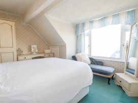 A bedroom with a bed, mirror, and dressing table at 22 Pentire Avenue Newquay