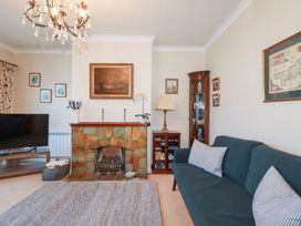 A living room with a sofa and television at Pipers in Newquay