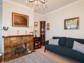 A living room with a sofa and fireplace at Pipers in Newquay