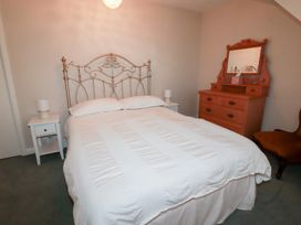 A bedroom with a bed and dresser at Pipers in Newquay