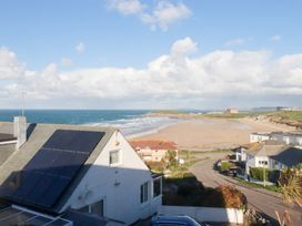 A beach view with ocean and houses at Pipers in Newquay