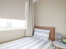 A bedroom with a bed and bedside table at Pipers in Newquay