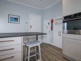 A kitchen with a table and stools at Pipers in Newquay