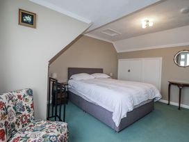A bedroom with a bed and nightstand at Pipers in Newquay