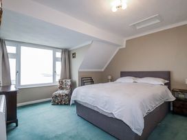 A bedroom with a bed and a chair at Pipers in Newquay