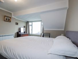 A bedroom with a bed and dresser at Pipers in Newquay