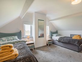 A bedroom with two single beds bedside tables lamps and folded towels at Bryn Derw in Caernarfon