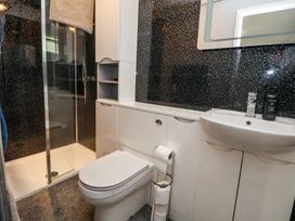 A bathroom with a toilet sink shower enclosure and storage cabinets at 155 Woodland Hall Lyons in Ruthin