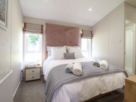 A bedroom with a bed bathtub and bedside table at The Owlet in Dolwen near Llanidloes