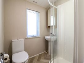 A bathroom with a toilet sink shower and window with blinds at The Owlet in Dolwen near Llanidloes