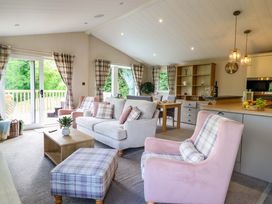 A living room with a sofa and dining area at The Owlet in Dolwen near Llanidloes