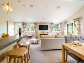 A living room with a sofa and television at The Owlet in Dolwen near Llanidloes