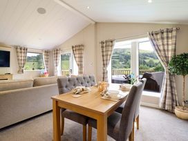 A living room with a dining table and sofa at The Owlet in Dolwen near Llanidloes