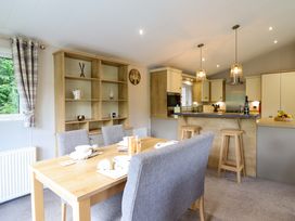 A kitchen with a dining area featuring a table and chairs at The Owlet Dolwen near Llanidloes