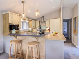 A kitchen with bar stools and a fruit bowl at The Owlet in Dolwen near Llanidloes