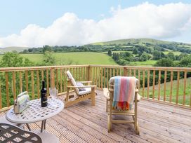 An outdoor area with garden chairs and a table at The Owlet Dolwen near Llanidloes