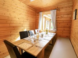 A dining room with a wooden table and chairs at Dan Y Coed near Beggar's Bush near Presteigne