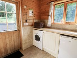 A laundry room with a washing machine and a fridge at Dan Y Coed in Beggar's Bush near Presteigne