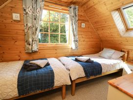 A bedroom with twin beds and wooden walls at Dan Y Coed near Beggar's Bush near Presteigne