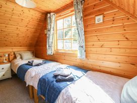 A bedroom with two beds and a window at Dan Y Coed in Beggar's Bush near Presteigne