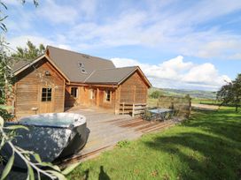 An outdoor area with a hot tub and seating at Dan Y Coed in Beggar's Bush near Presteigne