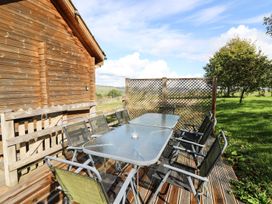 An outdoor dining area with a table and chairs at Dan Y Coed in Beggar's Bush near Presteigne