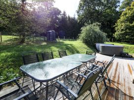 An outdoor area with a table and chairs near a hot tub at Dan Y Coed near Beggar's Bush near Presteigne