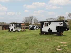 Cow-themed accommodation units and outdoor seating at Carabelle (Cow Shed 7) Woodbridge