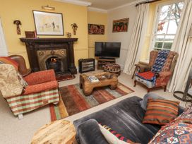 A living room with a fireplace and television at Elford Farmhouse, Seahouses