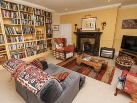A living room with a fireplace and bookshelf at Elford Farmhouse in Seahouses