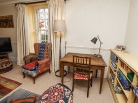 A living room with a desk and lamp at Elford Farmhouse in Seahouses
