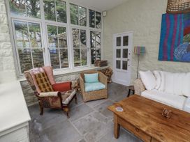 A conservatory with seating and a wooden table at Elford Farmhouse in Seahouses