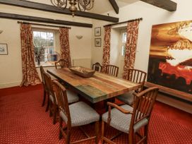 A dining room with a wooden table and chairs at Elford Farmhouse in Seahouses