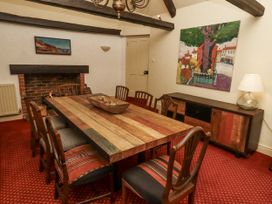 A dining room with a wooden table and chairs at Elford Farmhouse in Seahouses