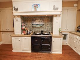 A kitchen with a cooker and utensils at Elford Farmhouse in Seahouses