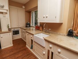 A kitchen with a sink, oven, and coffee machine at Elford Farmhouse in Seahouses