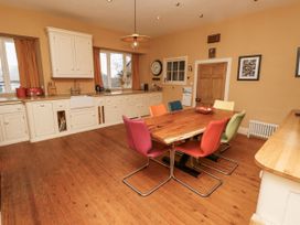 A kitchen with a dining table and colorful chairs at Elford Farmhouse in Seahouses