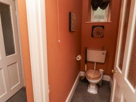 A bathroom with a toilet and wall art at Elford Farmhouse in Seahouses
