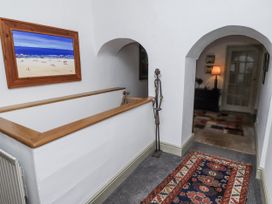 A hallway with a painting and a lamp at Elford Farmhouse in Seahouses