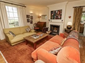 A living room with sofas and a fireplace at Elford Farmhouse in Seahouses