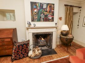 A living room with a fireplace and artwork at Elford Farmhouse in Seahouses