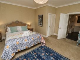 A bedroom with a bed and art on the wall at Elford Farmhouse Seahouses