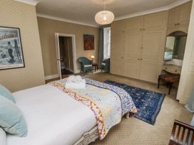 A bedroom with a bed and wardrobe at Elford Farmhouse in Seahouses
