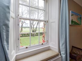 A window with a view of grass and trees at Elford Farmhouse in Seahouses