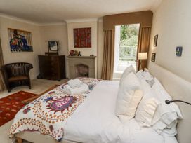 A bedroom with a bed and armchair at Elford Farmhouse in Seahouses