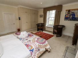 A bedroom with a bed and wardrobe at Elford Farmhouse in Seahouses