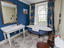 A bathroom with a bathtub and sink at Elford Farmhouse in Seahouses