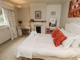 A bedroom with a bed and desk at Elford Farmhouse in Seahouses