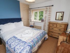 A bedroom with a bed and dresser at Elford Farmhouse Seahouses