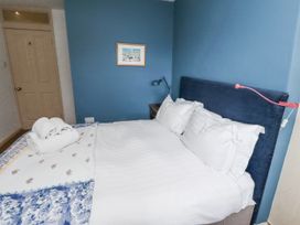 A bedroom with a bed and a lamp at Elford Farmhouse in Seahouses